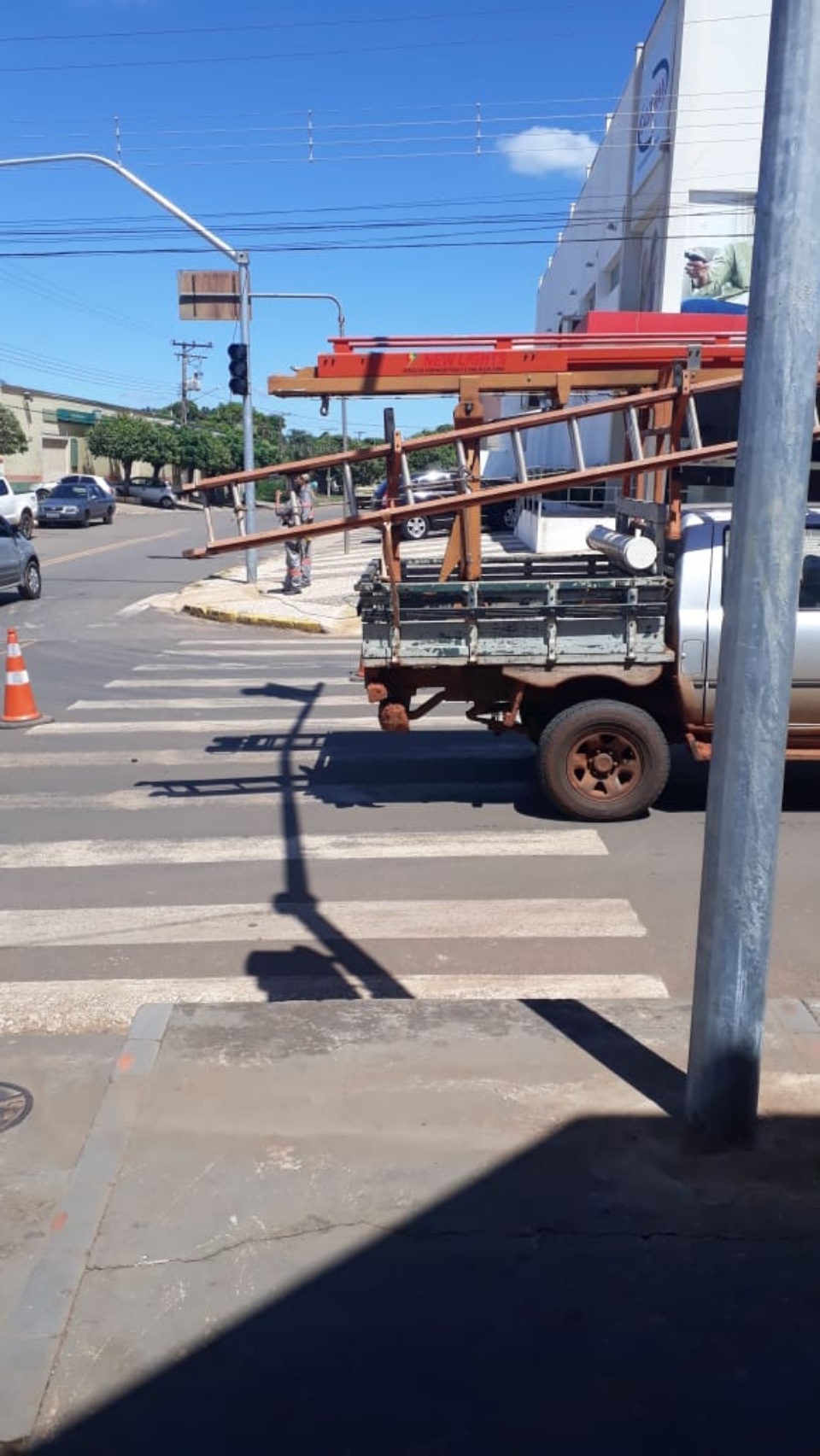 Caminhão transportando máquina danifica fios de semáforo